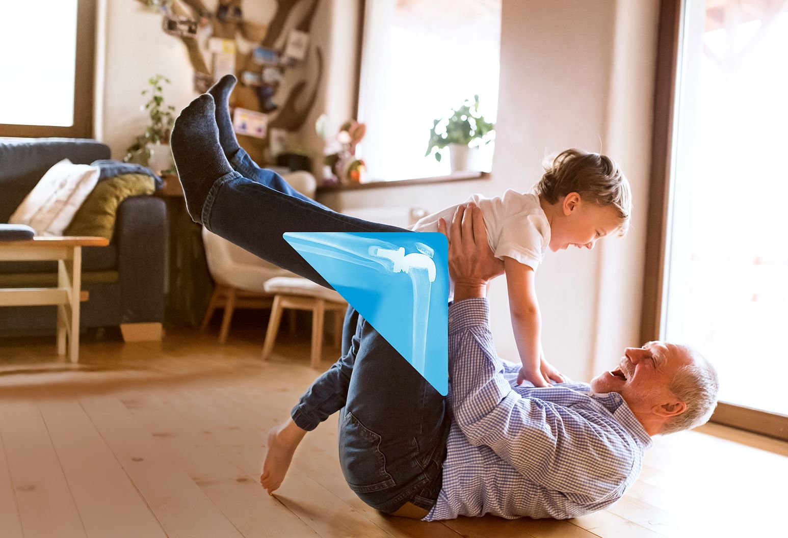 Grandpa holding grandson on the floor.